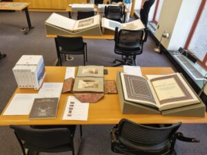 Tables in a library with a display of books and photograph albums from the Aga Khan Documentation Center’s collections. The books are opened on foam supports.