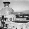 Workers stand around a dome on a rooftop during construction