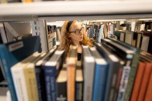 Woman looking at book stacks