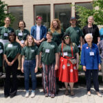 Two rows of people stand in a courtyard