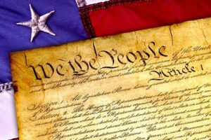 The US Constitution against an American flag background